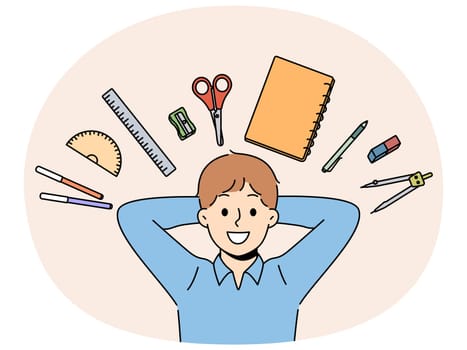 Back to school concept, with boy lying among stationery for learning and gaining new knowledge. Happy child rejoices at beginning of school year and opportunity to go to primary school