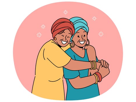 Happy adult mother and daughter in national african clothes embrace together, rejoicing at meeting. Mature woman hugging elderly mother, feeling gratitude and recognition for good upbringing