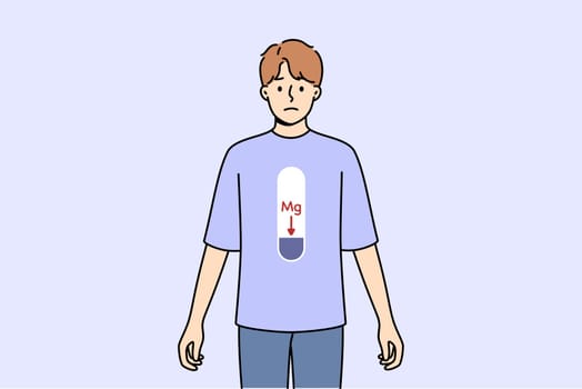 Magnesium deficiency in body of man with MG scale on stomach, and negative emotions on face. Problem of magnesium deficiency negatively affects health of bones and teeth or cardiovascular system