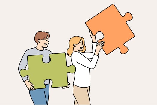 Couple of man and woman are working on building relationships, holding puzzle pieces in hands