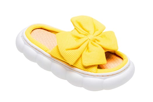Slippers isolated. Close-up of a single female yellow soft cosy house slipper with a large bow isolated on a white background, Clipping path. Macro. Womans shoes.