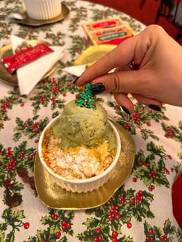 Festive dessert table with holiday-themed decorations. a warm crumble topped with a scoop of ice cream and a Christmas tree decoration captures the cozy atmosphere of a winter celebration. Festive and joyful winter celebrations. Xmas treats.