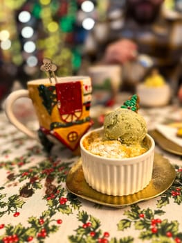 Festive dessert table with holiday-themed decorations. a warm crumble topped with a scoop of ice cream and a Christmas tree decoration captures the cozy atmosphere of a winter celebration. Festive and joyful winter celebrations. Xmas treats.