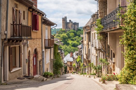 Main street in the village of Najac, one of the most beautiful villages of France, offering fantastic view over the emerging medieval castle, Aveyron, France