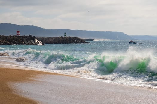 Nazaré beach, wave and cliffs in the Atlantic Ocean, Algarve, Portugal