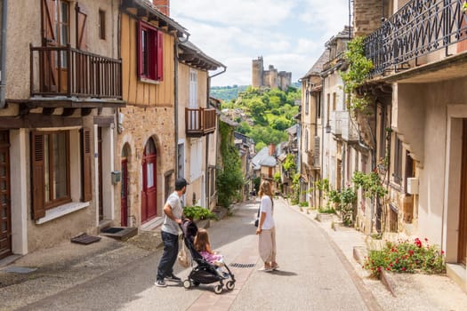 Najac, France- June 03 2024: Tourists visiting the main street in the village of Najac, one of the most beautiful villages of France, offering fantastic view over the emerging medieval castle, Aveyron, France