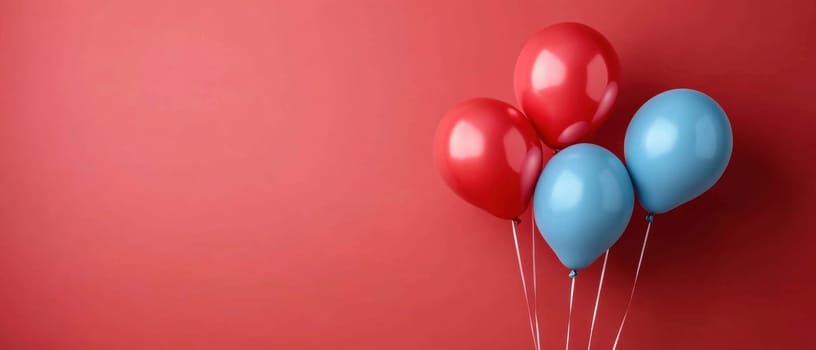 Four bright balloons float on a vibrant red backdrop creating a festive atmosphere ideal for celebrations or parties.