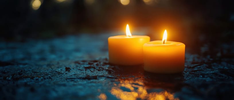 Two lit candles cast a warm glow in a dim environment creating a serene and peaceful atmosphere surrounded by reflections.