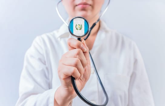 Female doctor holding stethoscope with Guatemala flag. Guatemalan Health and Care concept