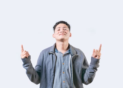 Happy handsome man pointing an advertising up isolated. Young man pointing blank space up and smiling at camera