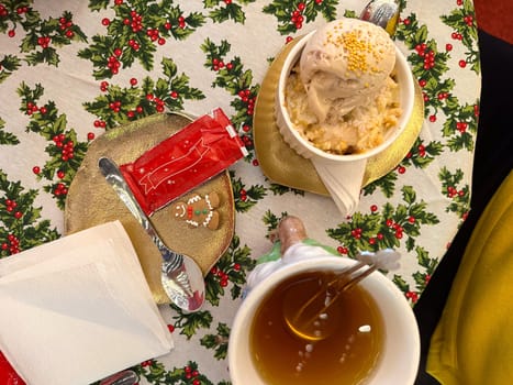 Festive dessert table with holiday-themed decorations. a warm crumble topped with a scoop of ice cream and a Christmas tree decoration captures the cozy atmosphere of a winter celebration. Festive and joyful winter celebrations. Xmas treats.