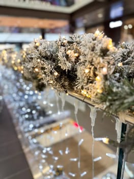 Close-up shot captures a beautifully frosted garland adorned with twinkling lights in Christmas festive indoor setting. Warm glow creates a magical atmosphere, perfect for the holiday season.