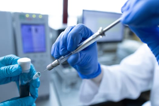 Scientist injecting a sample via the autosampler of HPLC system. High performance liquid chromatography at chemical laboratory. Developing of pharmaceuticals or vaccine. Biochemistry analysis