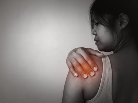 Woman with acute pain shoulder with neck pain on gray background, Shoulder inflammation and arm, Female massaging her shoulder muscle spasm, Healthcare and medical concept, Injuries and medical.