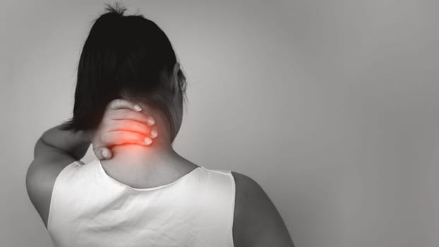 Woman with acute pain spine disease with neck pain on gray background, neck pain and spine disease treatment, Female massaging her neck muscle spasm, Healthcare and medical, Injuries and medical.