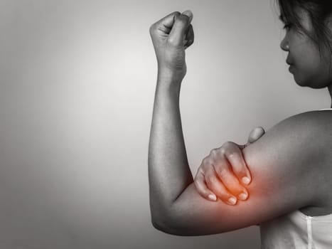 Woman with acute pain elbow with arm pain on gray background, Elbow and arm treatment, Female massaging her elbow muscle spasm, Healthcare and medical concept, Injuries and medical concept.