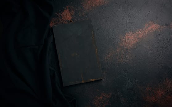 Empty black wooden cutting board and linen kitchen towel, top view. Copy space