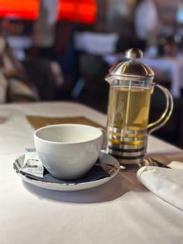 Tea setting featuring a cup and a French press. Soft focus background enhances the inviting atmosphere of a relaxed dining experience.