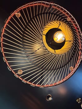 An artistic ceiling light fixture with intricate rope design, lamp. Warm, glowing bulb creates a cozy ambiance and striking visual effect.