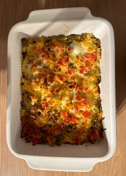 Close-up delicious homemade baked pasta casserole with melted cheese and vegetables. Italian cuisine food for a hearty meal.