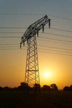 Atmospheric sunrise on a field with a power pole in the early morning in Germany