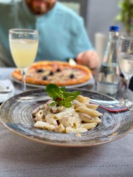 Savoring delicious italian cuisine at an elegant al fresco dinner. Beauty and pleasure of enjoying fine dining in a relaxed outdoor setting.