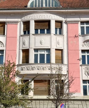 Ornate details of a historic building facade illuminated by sunlight. the intricate architectural elements and pastel colors highlight the building's elegance and charm.