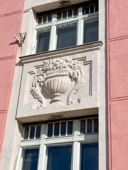 Ornate details of a historic building facade illuminated by sunlight. the intricate architectural elements and pastel colors highlight the building's elegance and charm.