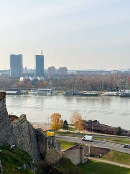 Looking across the Sava river in Belgrade, river boats in the foreground and a variety of office blocks in the distance. Belgrade in autumn season.