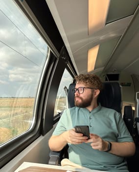 Man traveler enjoying a serene view from a train window. Calm and reflection during a peaceful journey.