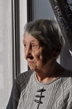 Head shot close up portrait of thoughtful senior woman worrying about personal health problems. Upset older female thinking of family troubles, feeling lonely, sitting at home.