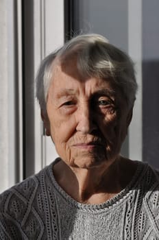 Head shot close up portrait of thoughtful senior woman worrying about personal health problems. Upset older female thinking of family troubles, feeling lonely, sitting at home.