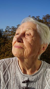 Portrait of beautiful senior woman posing in autumn park