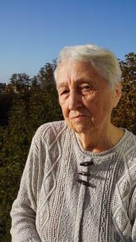 Portrait of beautiful senior woman posing in autumn park