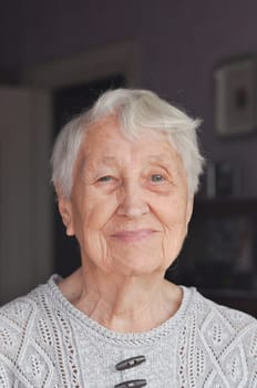 Portrait of elderly woman near window, Grandmother smiling