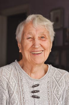 Portrait of elderly woman near window, Grandmother smiling