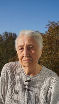 Portrait of beautiful senior woman posing in autumn park