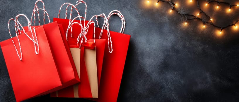 Red gift bags with festive lights on a dark background, creating a holiday shopping atmosphere. Black Friday sale concept with empty place for text.