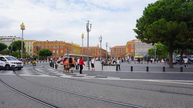 Nice, France - September 22, 2024: People going at Place Massena - people, transport and architecture in cloudy weather, city views of Nice, French Riviera, France