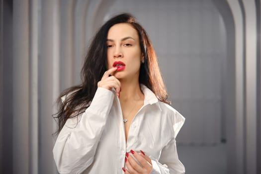 Playful woman biting her fingernail