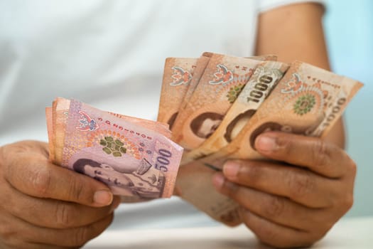 Asian woman counting Thai baht banknote money, investment economy, accounting business and banking.