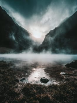Dramatic foggy landscape of a mountain valley with ethereal light breaking through, creating a mystical and moody atmosphere in nature.