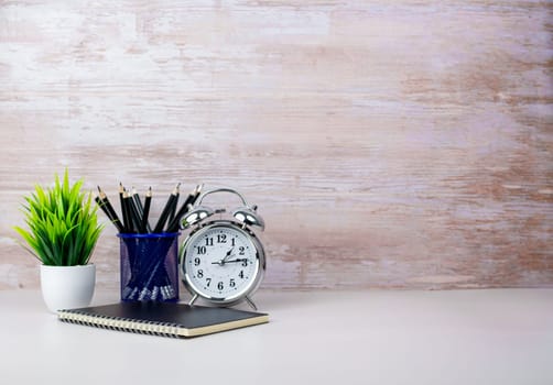 Workspace Mock up white table top with vintage notebook, pencils and green houseplant. Copy space desk with copy space for products display montage. Minimalist white workplace with supplies.