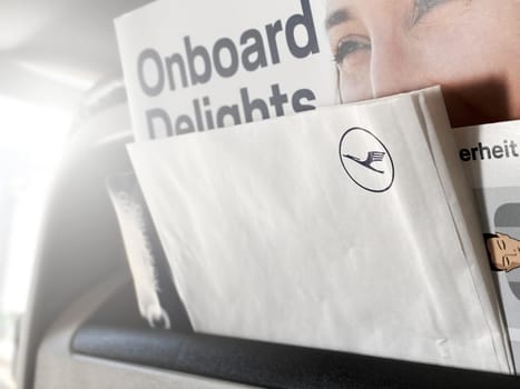 Frankfurt, DE, May 22 2022  Close-up of Lufthansa onboard materials, including a magazine and a safety card, placed in the seat pocket of an airplane.