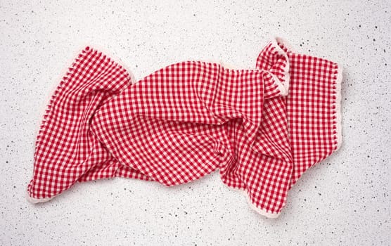 Folded red kitchen towel on a white background, top view.