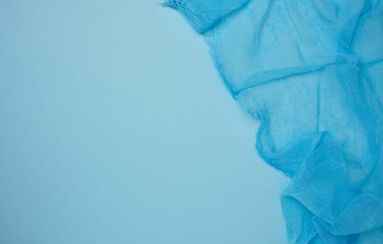 Blue gauze kitchen towel on blue background, top view. Copy space