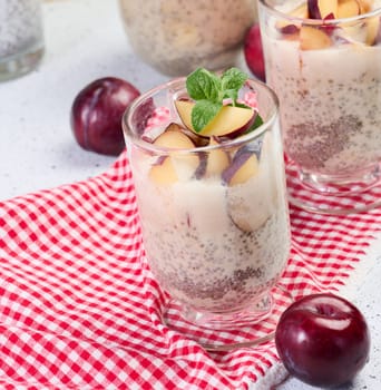 A glass of chia seeds and yogurt, with pieces of plum