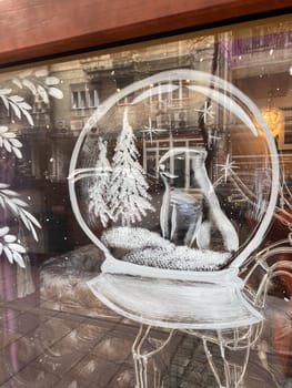 Frosted ornaments delicately decorate a window, showcasing hand-painted Christmas winter scenes with snowy landscapes and cozy cabins. Designs reflect festive spirit and charm of winter holiday season.