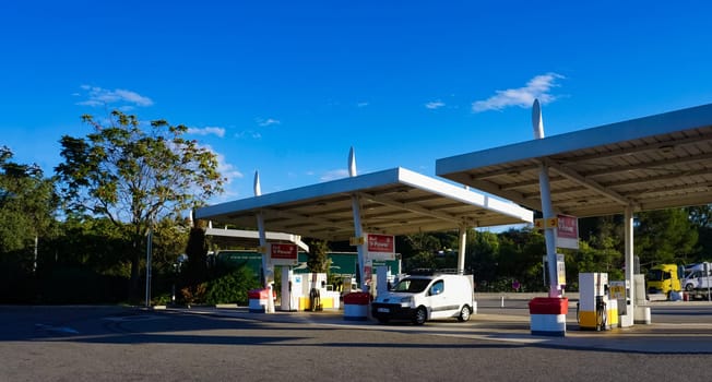 Aix-en-Provence, France - September 15, 2024: Side view of a Shell petrol station with cars and caravans along a motorway in France