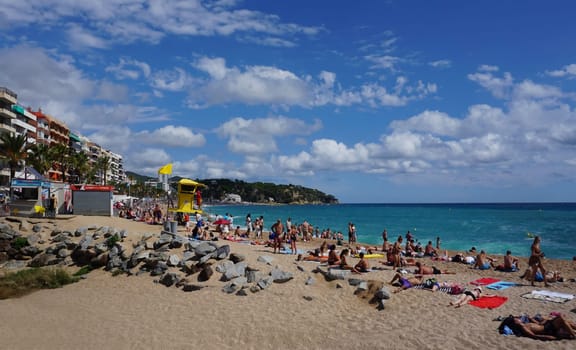 Lloret de mar, Spain - September 30, 2024: People resting at the beach of Lloret De Mar. The beach in Costa Brava of Catalonia at sunny day